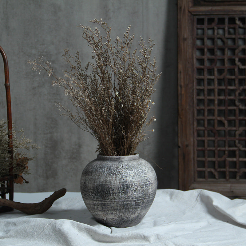 Grey white round ceramic vase with dried branch arrangement
