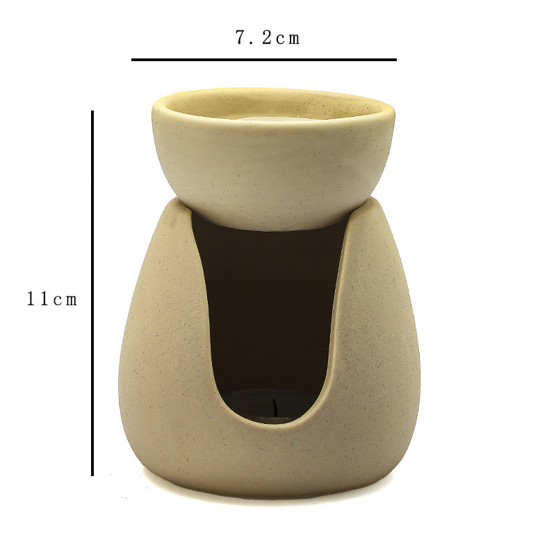 Black ceramic aroma burner with lit tealight candle in lower chamber