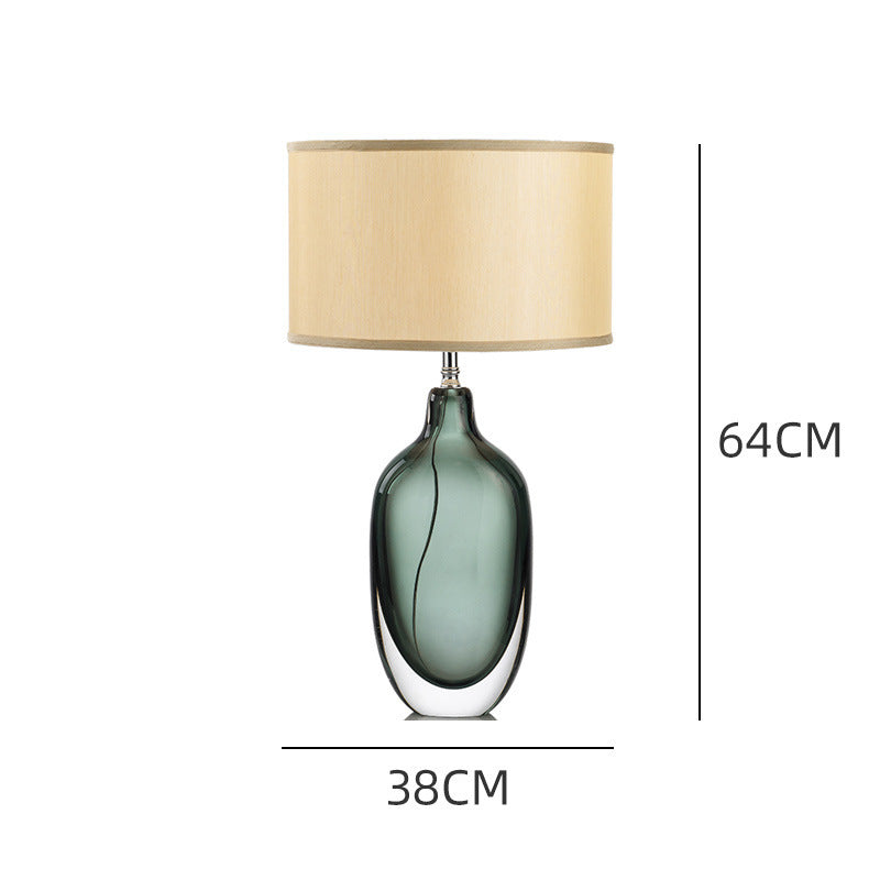 Green glass oval bedside lamp styled on black nightstand