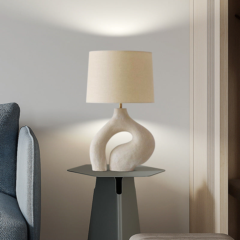 Off white organic loop table lamp styled on dark side table