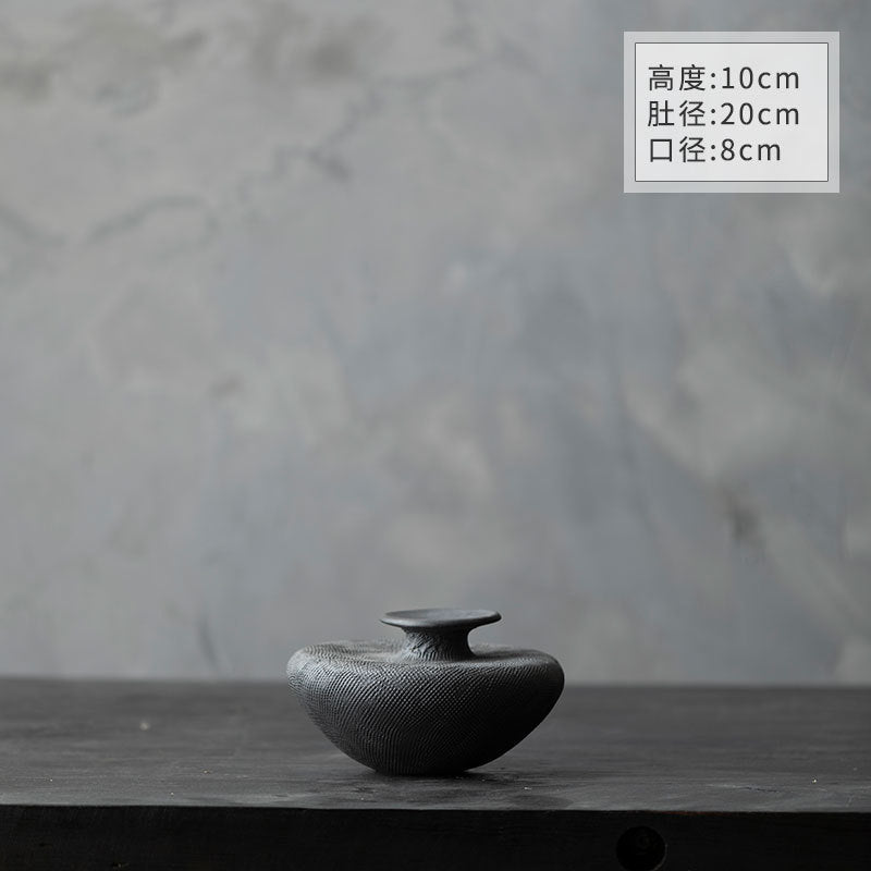 Black textured ceramic vase with pampas grass in wabi-sabi decor