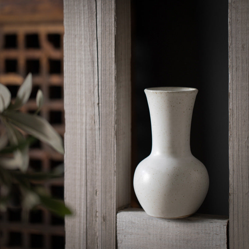 Ivory white tall flared-neck ceramic bud vase in rustic interior