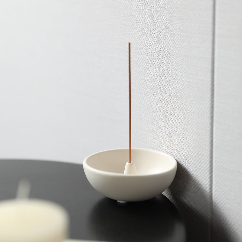 Milk white Japanese ceramic incense bowl with burning incense stick