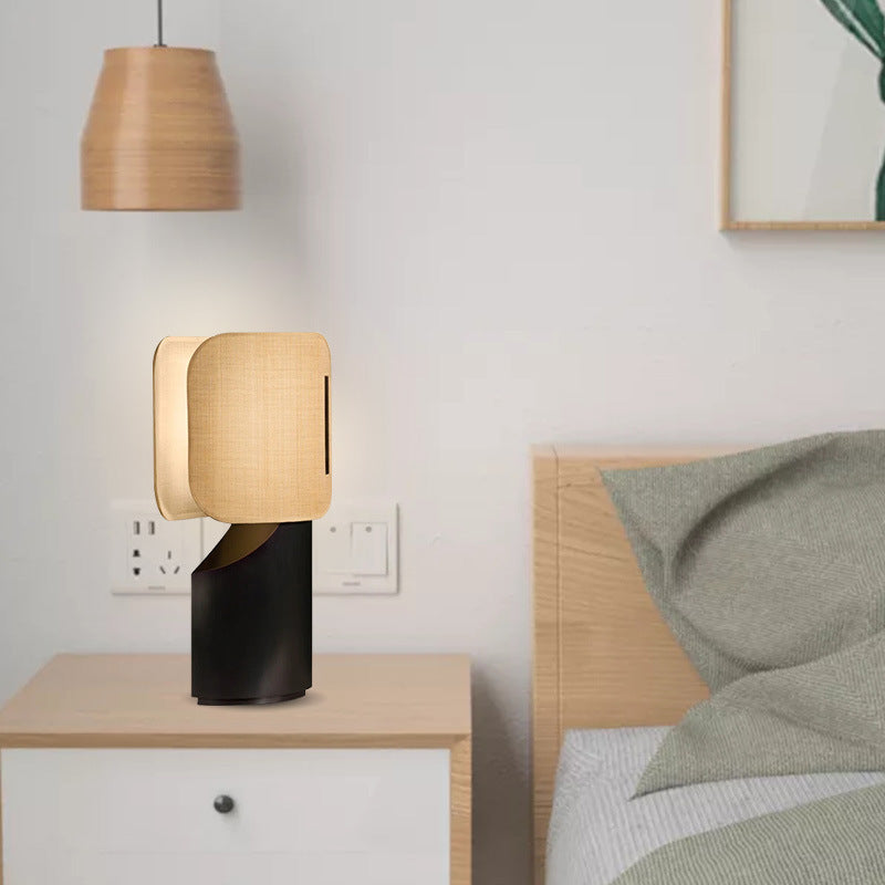 Warm fabric shade and black sculptural metal bedside lamp in neutral bedroom