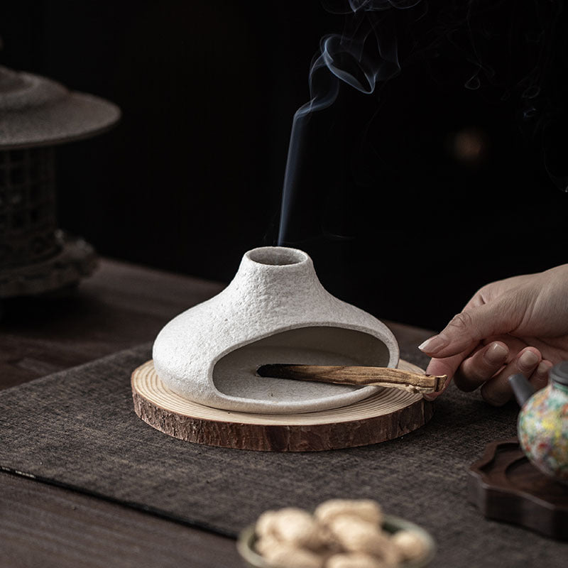 White ceramic smudge burner with wood base and burning sacred wood