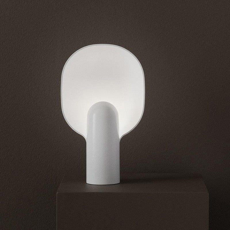 White sculptural resin table lamp with softly glowing rounded diffuser