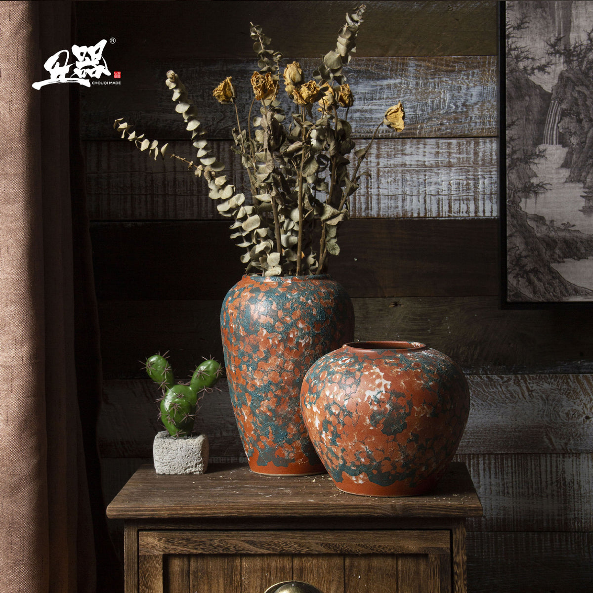 Three terracotta orange and blue-green patina ceramic vases styled together
