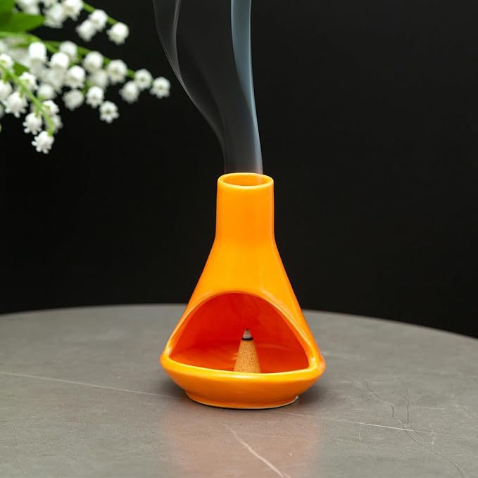 Orange ceramic chimney incense holder with smoke rising from top vent