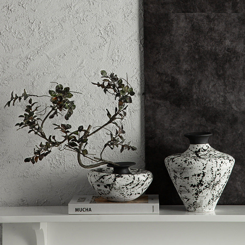 Black and white splatter ceramic vases styled on a minimalist shelf
