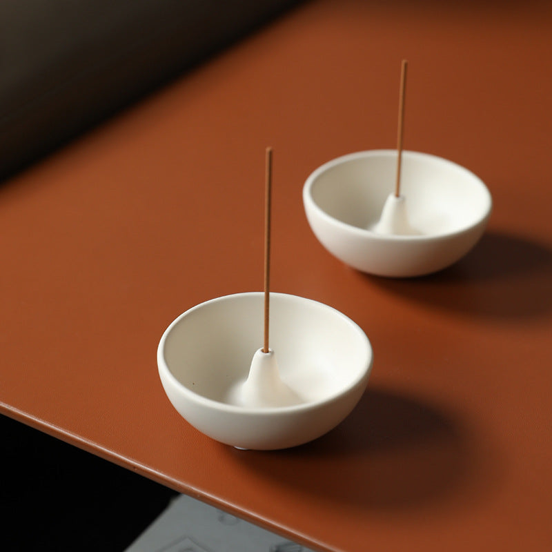 Japanese round ceramic incense bowl in milk white styled on a warm tabletop