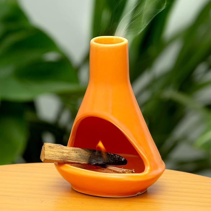 Orange ceramic Palo Santo holder burning sacred wood in open front chamber