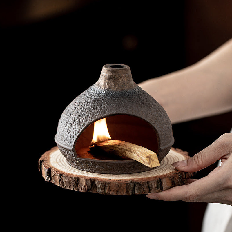 Warm hill ceramic sacred wood burner glowing on natural wood slice