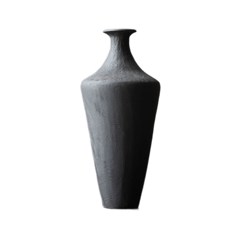 Three matte black sculptural ceramic vases in minimalist interior