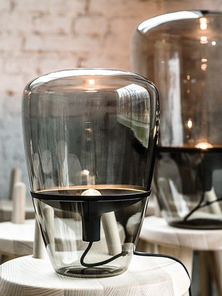 Smoke grey glass capsule lamp with black frame styled in modern cafe interior