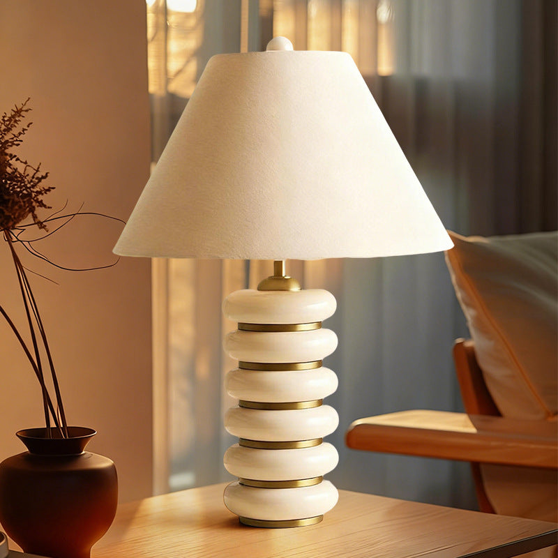 Cream sculptural stacked ring bedside lamp in warm interior