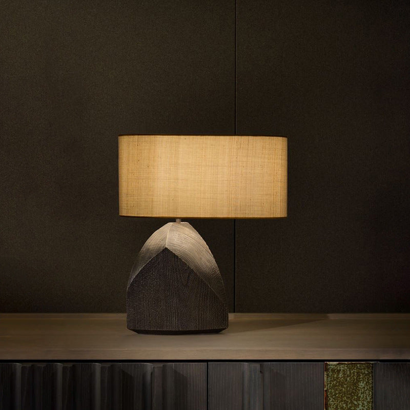 Warm glowing Zen table lamp on dark wood cabinet