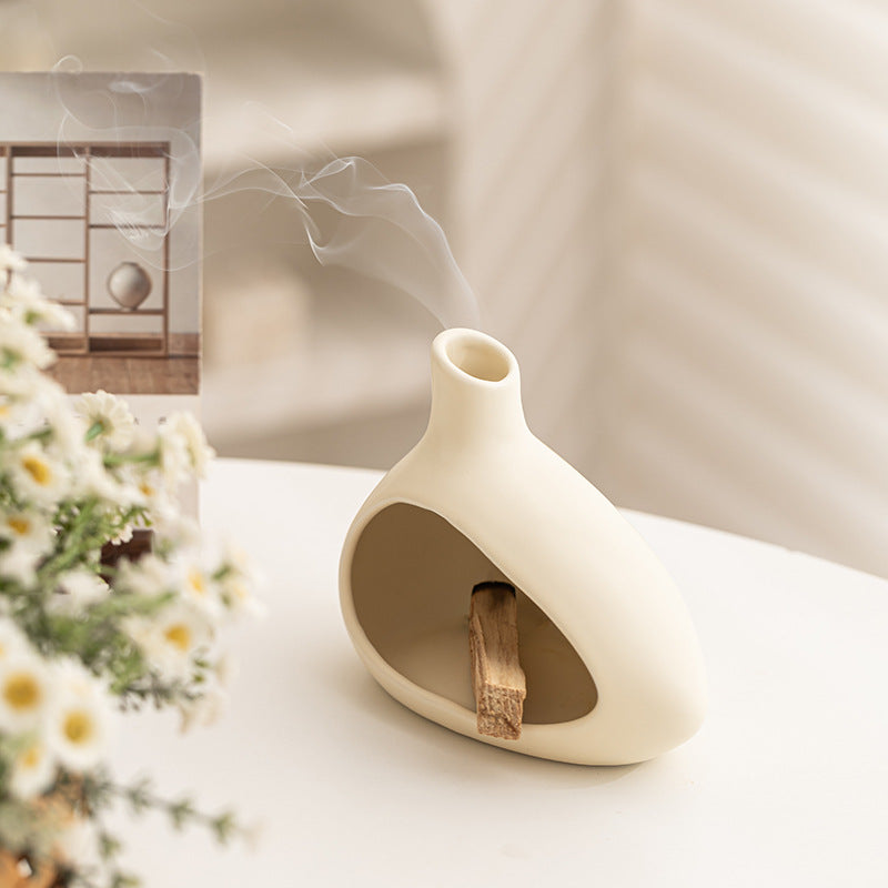 Cream ceramic incense and Palo Santo burner styled with soft modern home decor