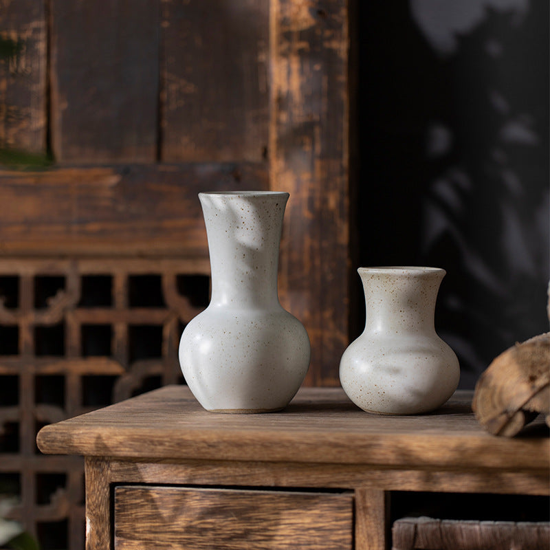 Ivory white flared-neck ceramic bud vase pair on rustic wood console