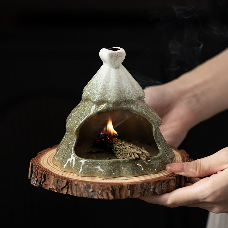 Green Christmas tree ceramic ritual fireplace held in hands with smoke rising