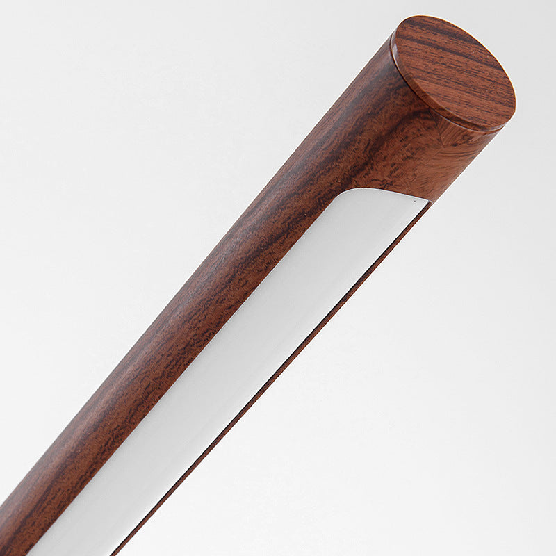 Architectural brass and wood grain LED table lamp on desk