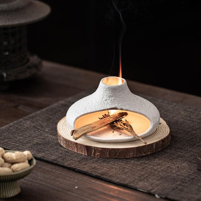 White ceramic Palo Santo burner with smoke rising through top vent