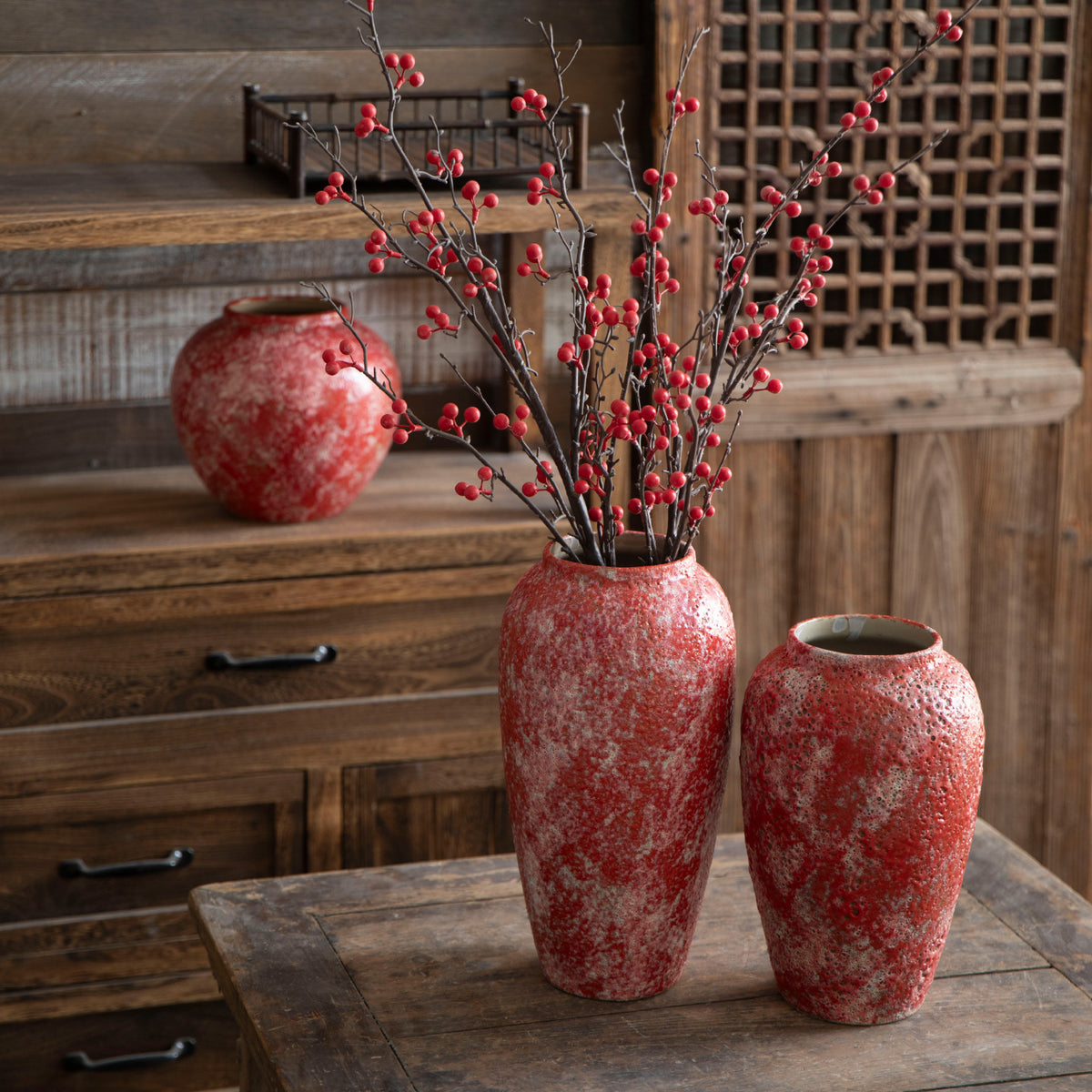 Berry red ceramic vases with festive red branch arrangement