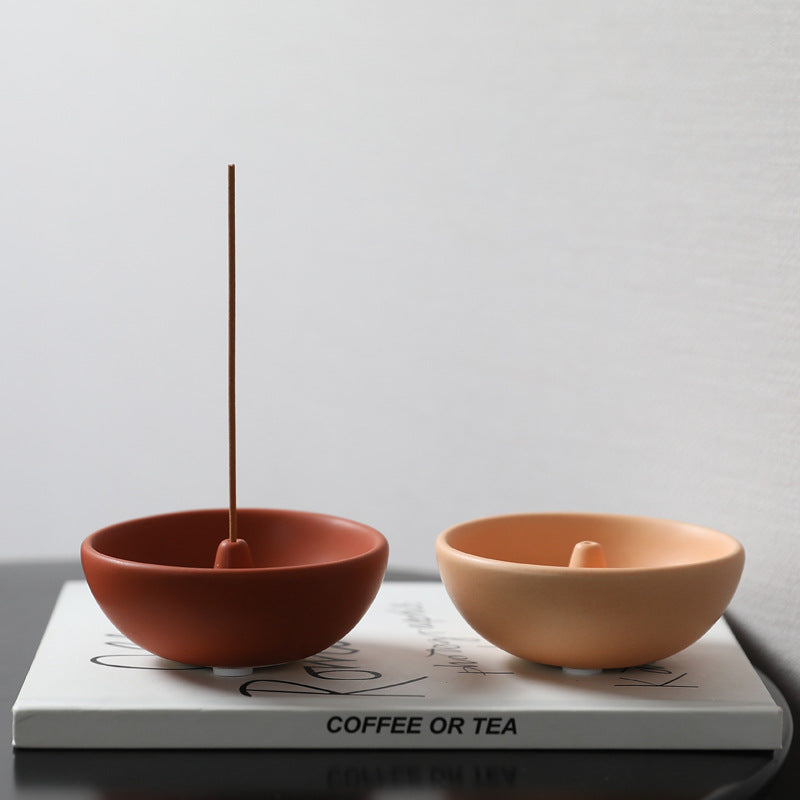 Red and light coffee incense bowls styled together with burning incense