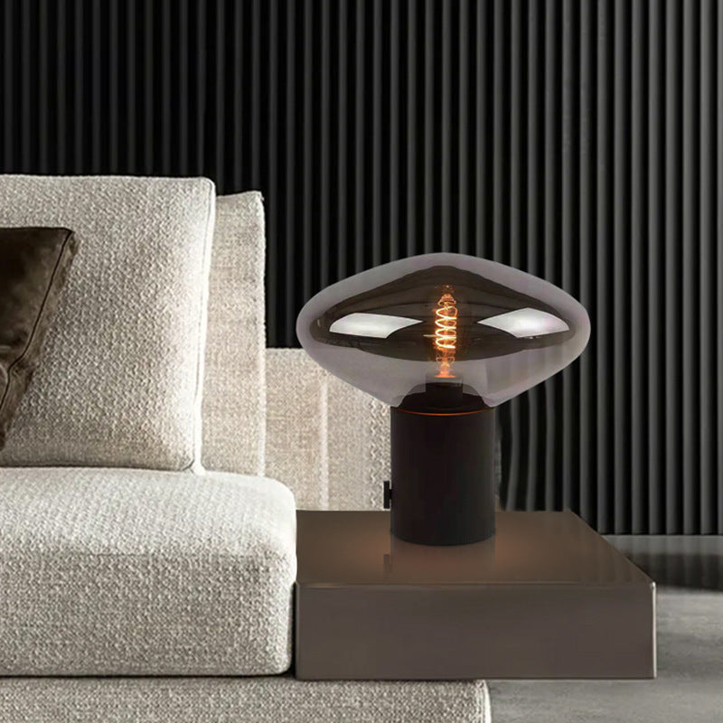 Smoked glass flying saucer lamp styled on bedside table