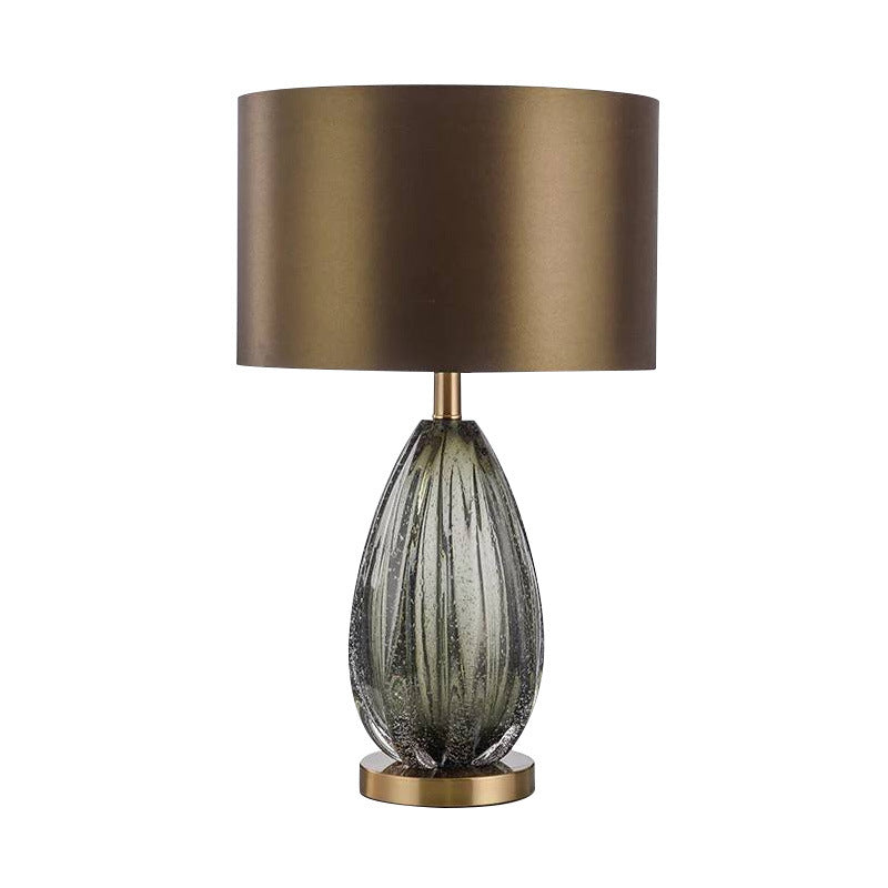 Ribbed grey green glass urn table lamp with ivory shade in elegant bedroom