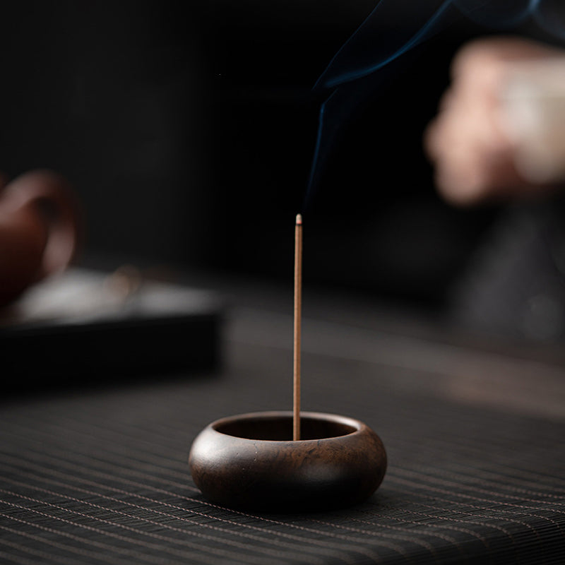 Dark ebony wood mini incense holder with thin incense stick in use