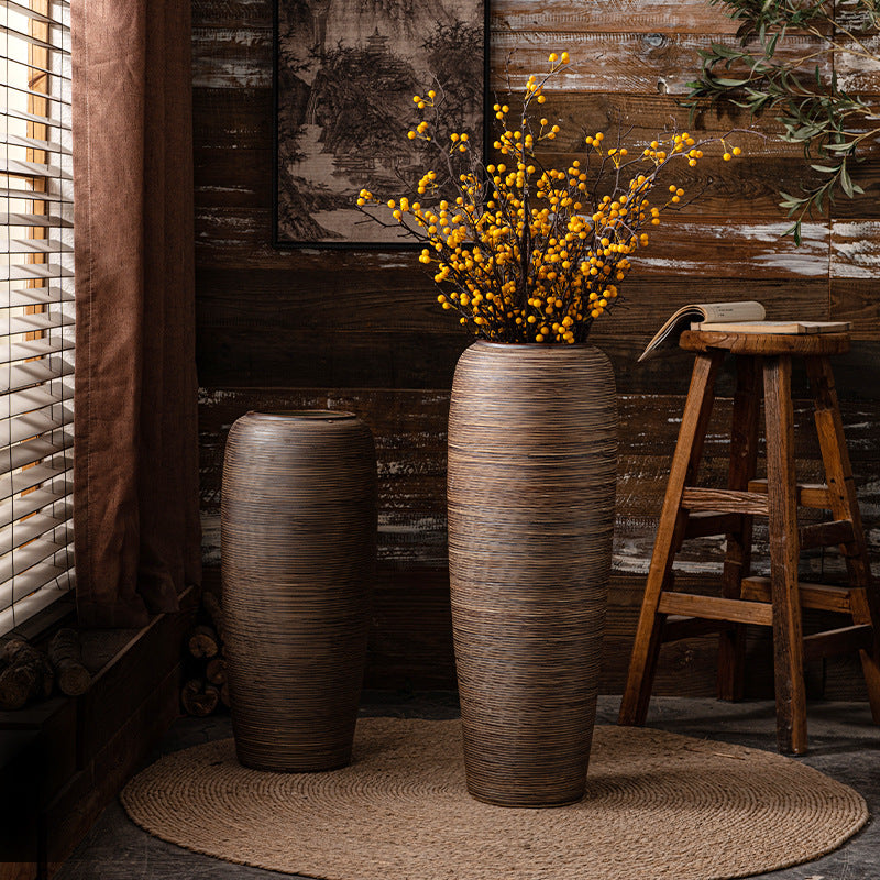 Two bronze brown ribbed ceramic floor vases styled with yellow branches