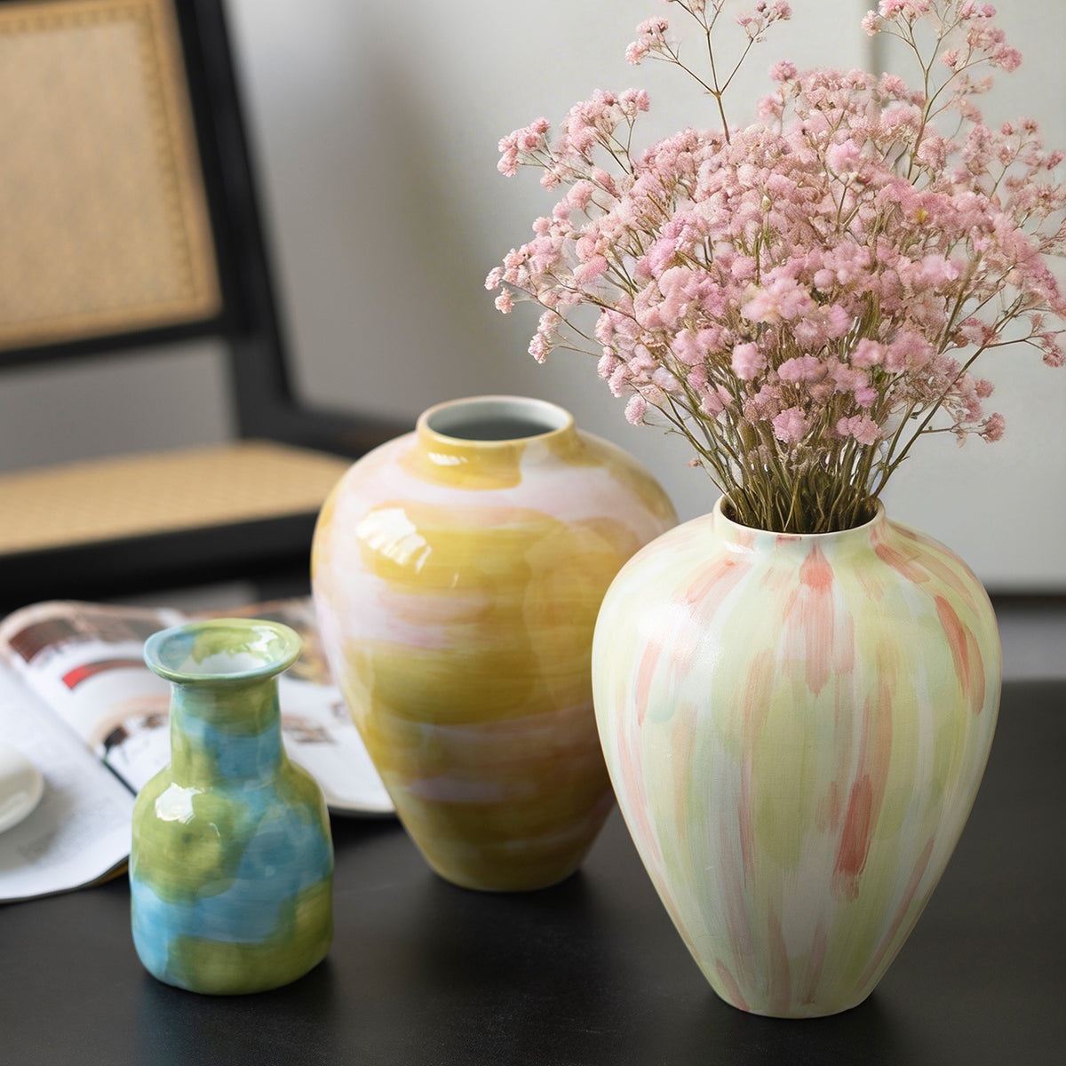 Three colorful glazed ceramic vases in blue green pink and ochre tones