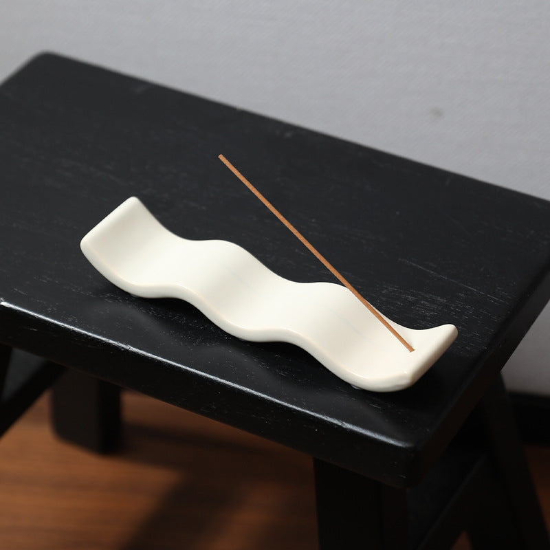 Milk white wave incense tray styled on a black side table