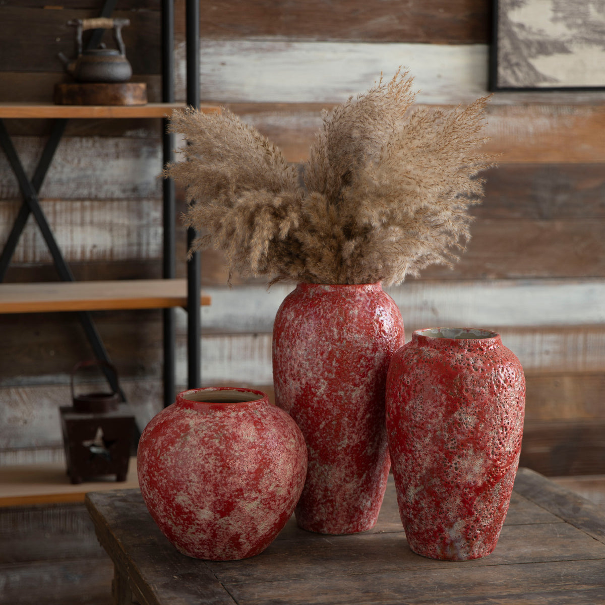 Three berry red rustic ceramic vases with dried pampas grass