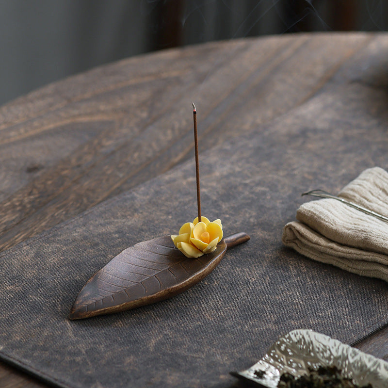 Fallen leaf osmanthus ceramic incense holder styled on a dark wood tea table