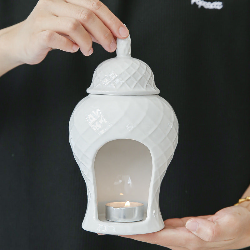 Ceramic fragrance warmer shown with essential oil added to top well