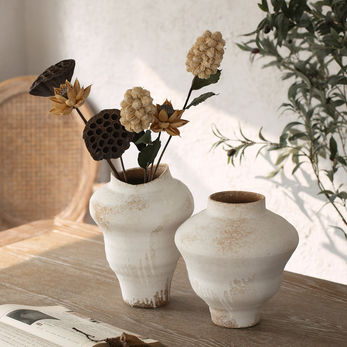 Aged white ceramic vase pair styled on natural wood