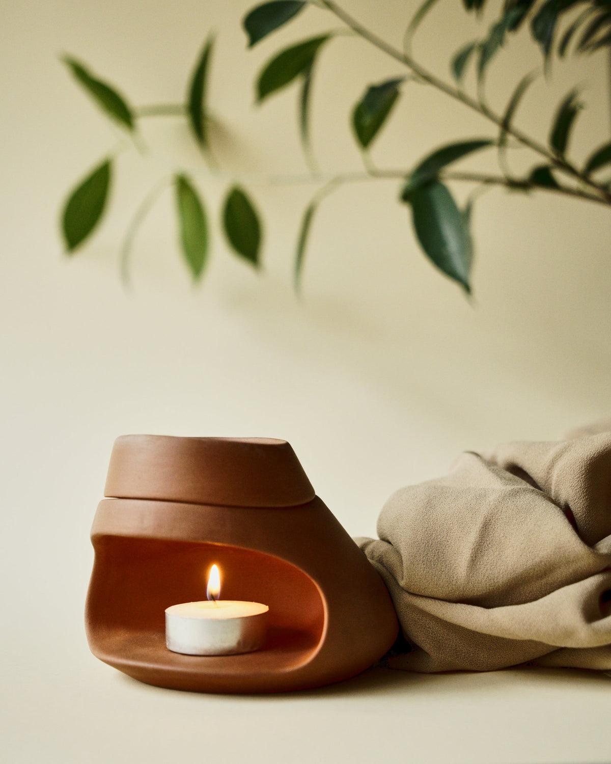 Terracotta ceramic essential oil burner with tealight candle in minimalist interior
