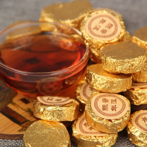 Gold foil wrapped 2003 aged Menghai ripe Pu-erh mini cakes with brewed tea