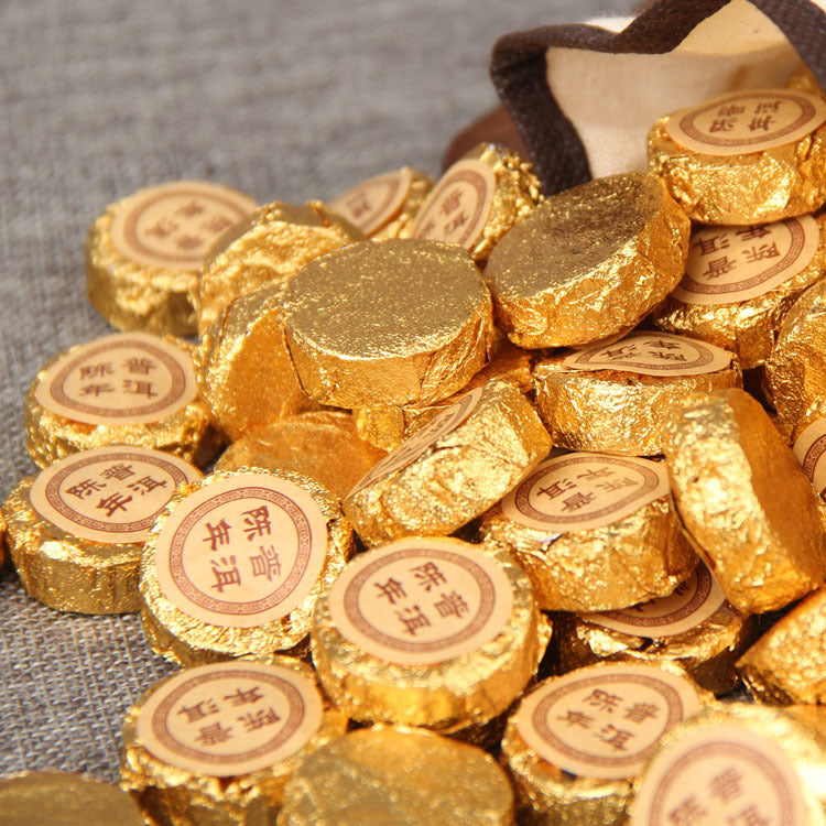 Pile of individually gold foil wrapped 2003 aged ripe Pu-erh mini cakes