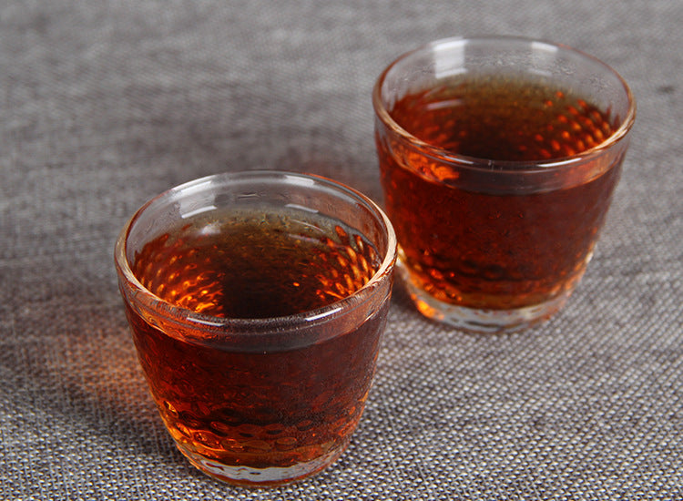Brewed aged ripe Pu-erh tea liquor served in tasting cups