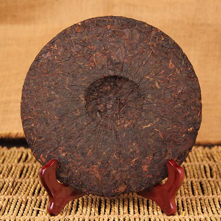 Back of unwrapped 2009 Eight-Year Aged Rhyme ripe Pu-erh tea cake showing compressed tea