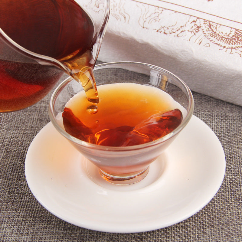 Amber-red liquor poured from 2012 Cang Chun Gu Yun ripe Pu-erh tea brick