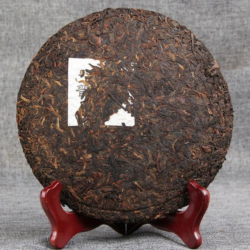 Unwrapped 2013 material 2017 pressed Menghai ripe Pu-erh tea cake showing compressed leaf surface