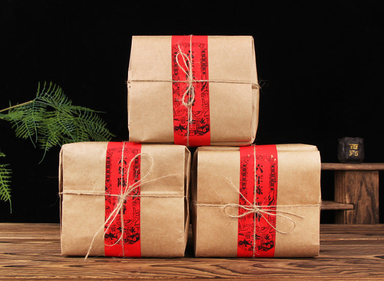Kraft-wrapped 500g packs of six-year aged Bulang Mountain sticky-rice aroma ripe Pu-erh