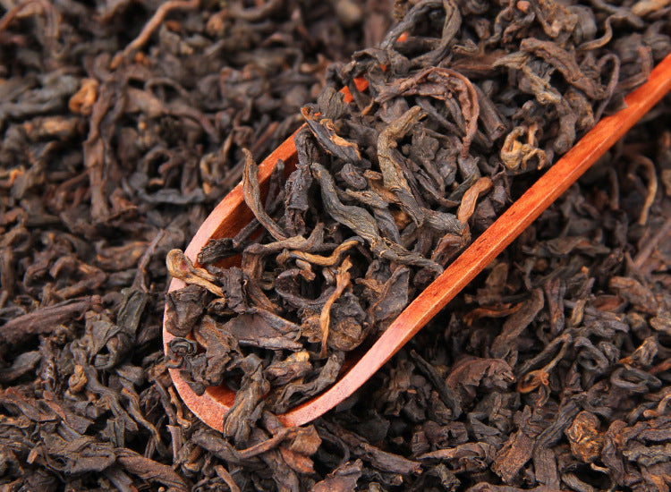 Loose six-year aged Bulang Mountain ripe Pu-erh tea displayed with wooden spoon
