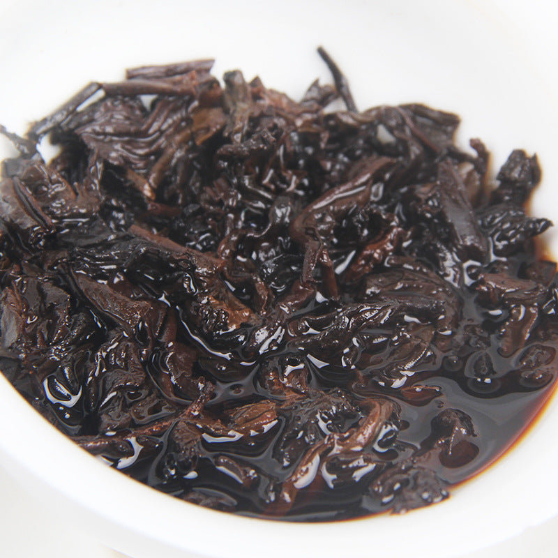 Deep red brewed liquor and wet leaves from Menghai ripe Pu-erh tea