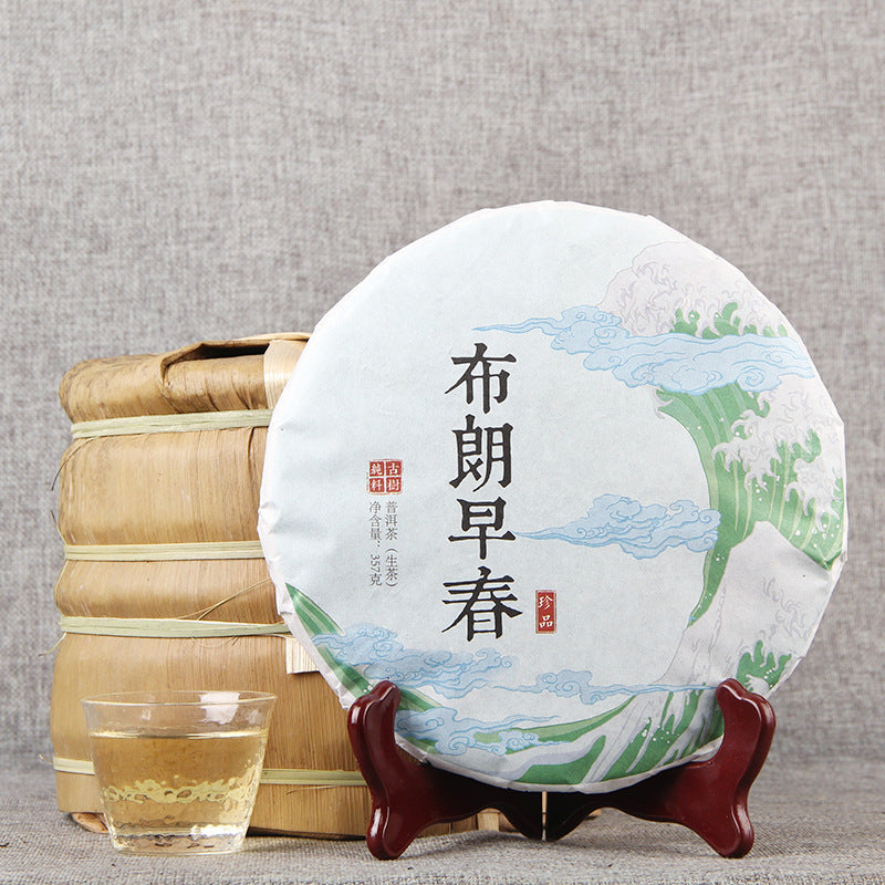 2020 Bulang Early Spring raw Pu-erh tea cake with bamboo-wrapped stack and tea cup