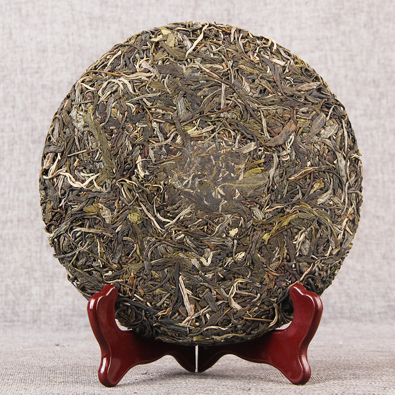 Unwrapped 2020 Bulang Early Spring raw Pu-erh tea cake showing compressed leaves and buds