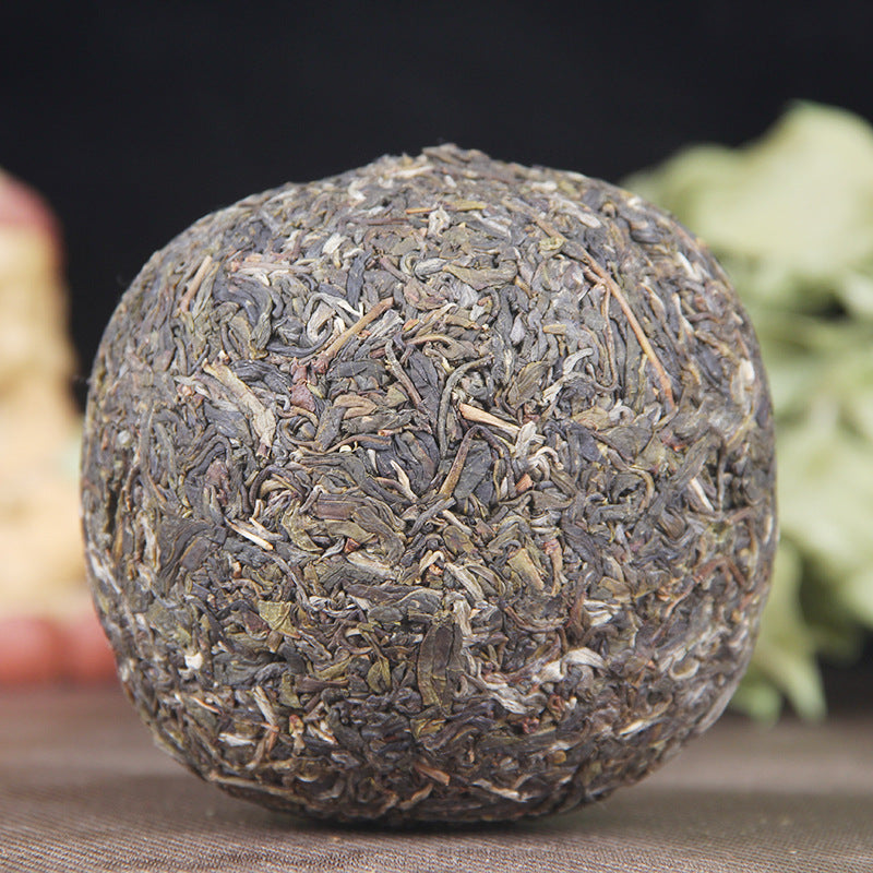Unwrapped 2021 Yiwu Bohetang raw Pu-erh golden melon showing compressed leaves